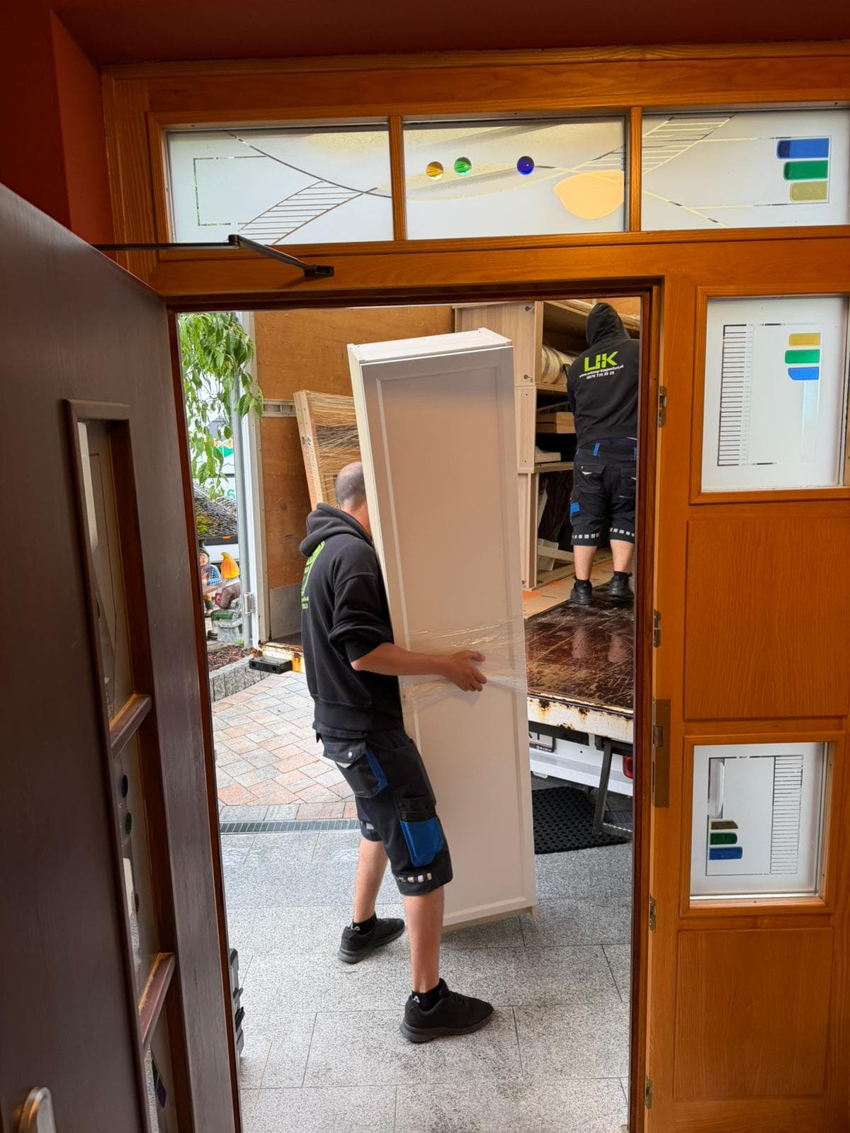 Umzugshelfer trägt einen Schrank